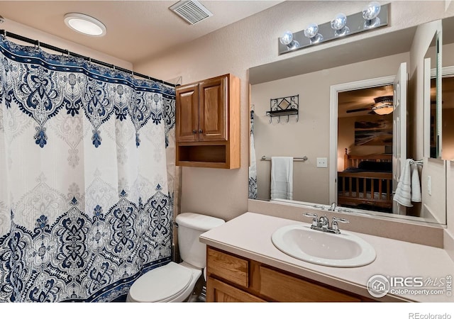 bathroom featuring a shower with curtain, vanity, and toilet