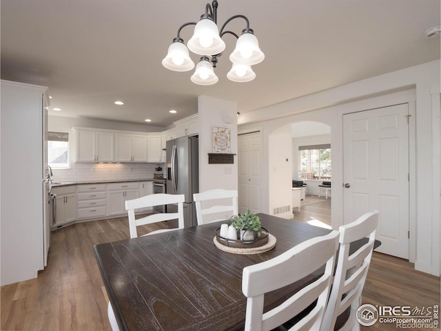 dining space featuring dark hardwood / wood-style floors and a chandelier