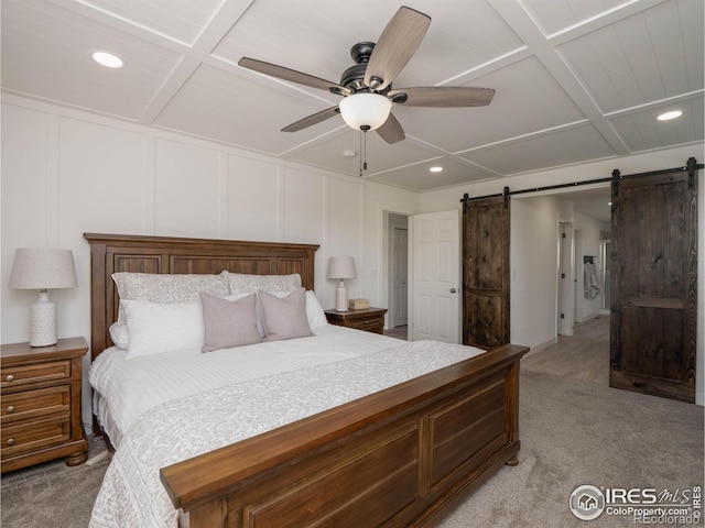 bedroom featuring a barn door, coffered ceiling, ceiling fan, and light carpet