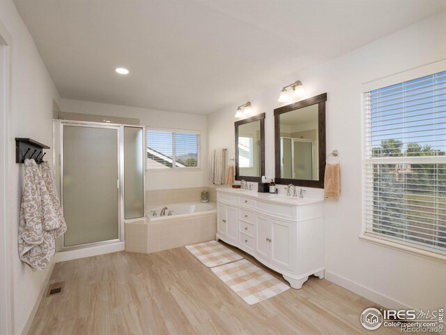 bathroom featuring independent shower and bath, vanity, and wood-type flooring