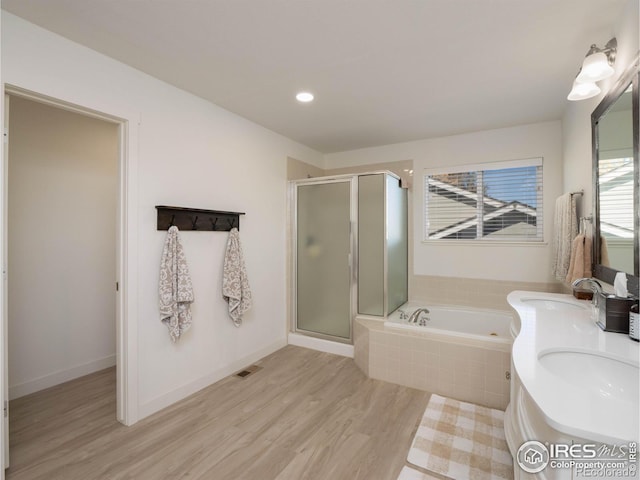 bathroom featuring plus walk in shower, hardwood / wood-style flooring, and vanity