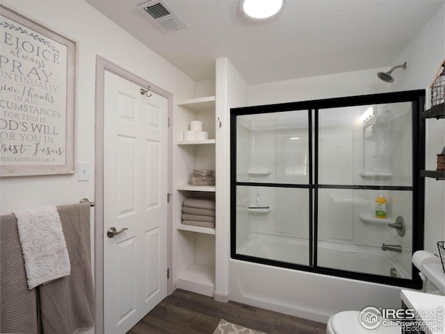 full bathroom featuring wood-type flooring, combined bath / shower with glass door, vanity, and toilet