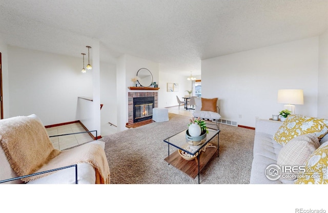 living room featuring carpet flooring, a fireplace, and a textured ceiling