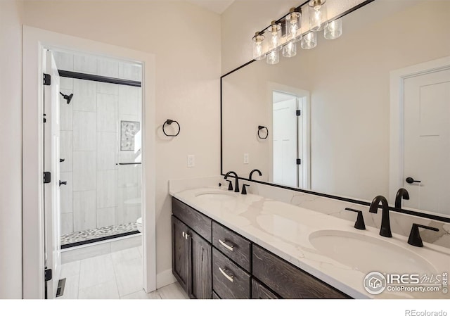 bathroom featuring tile patterned floors, a shower with shower door, vanity, and toilet