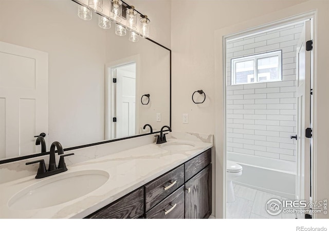 full bathroom featuring vanity, tiled shower / bath combo, and toilet