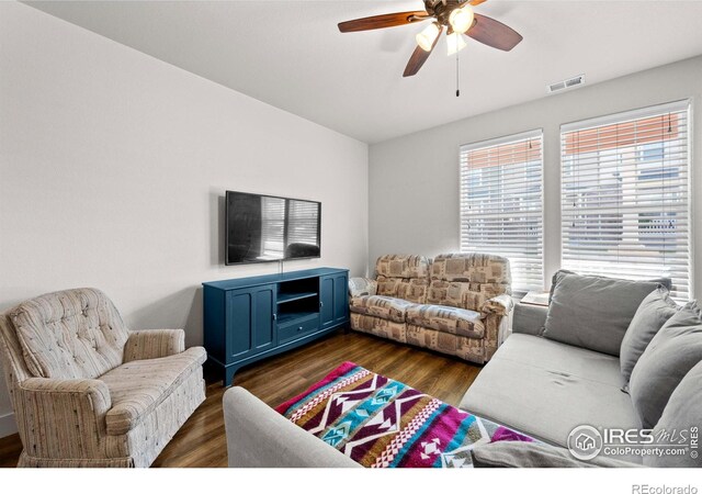 living room featuring ceiling fan and dark hardwood / wood-style floors