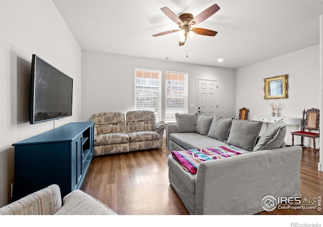 living room featuring ceiling fan and dark hardwood / wood-style floors