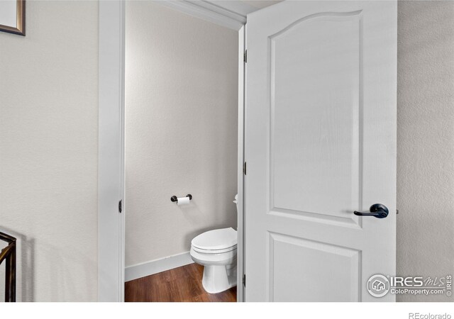 bathroom with toilet and hardwood / wood-style flooring