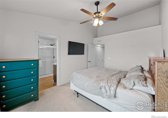 bedroom featuring ceiling fan, light colored carpet, a closet, and connected bathroom