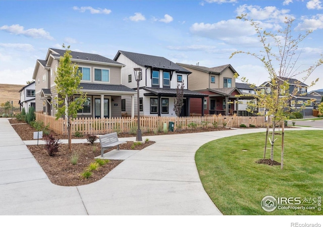 view of front facade featuring a residential view, a front yard, and a fenced front yard