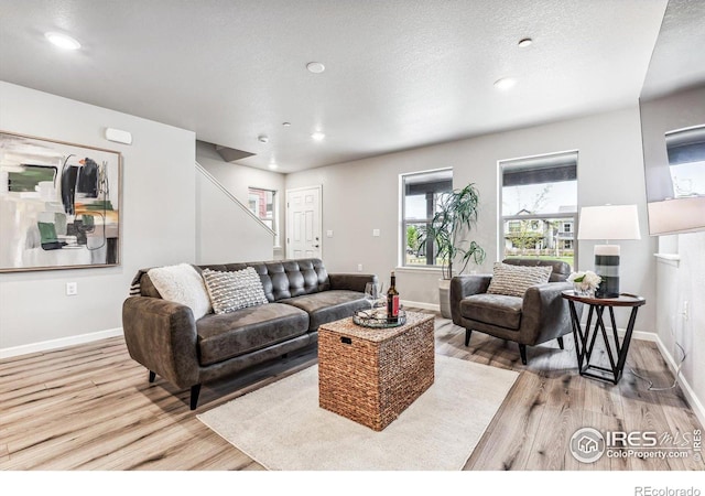 living area featuring recessed lighting, wood finished floors, stairs, and baseboards