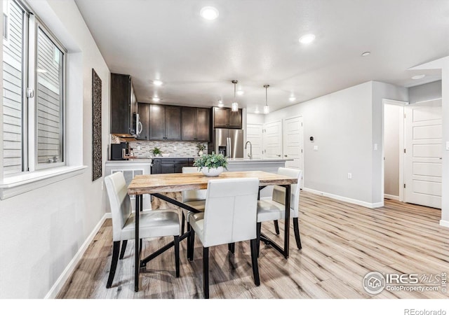 dining space with recessed lighting, light wood-style floors, and baseboards