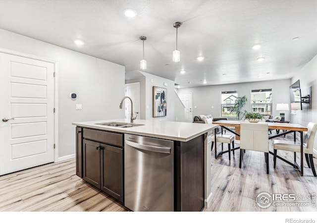 kitchen with dishwasher, a sink, dark brown cabinetry, light wood-style flooring, and open floor plan