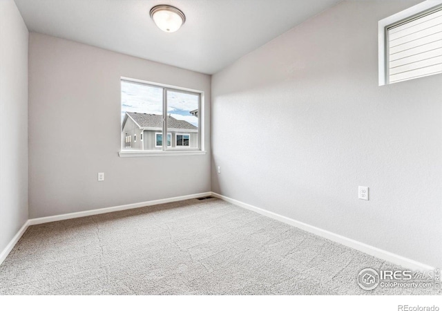 spare room with carpet and vaulted ceiling