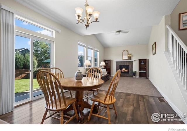 dining room with dark hardwood / wood-style floors, lofted ceiling, and a chandelier