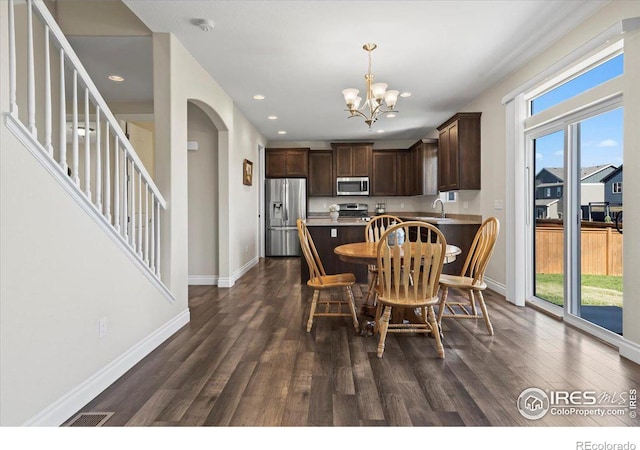 dining space featuring dark hardwood / wood-style flooring, plenty of natural light, a chandelier, and sink