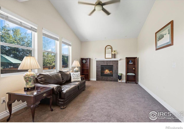 living room with carpet flooring, ceiling fan, lofted ceiling, and a tiled fireplace