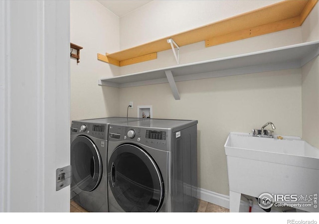 washroom featuring tile patterned floors, washer and clothes dryer, and sink