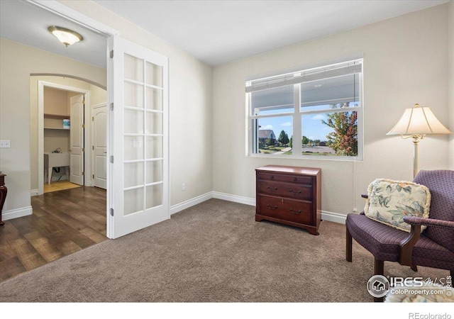 sitting room featuring french doors and dark carpet