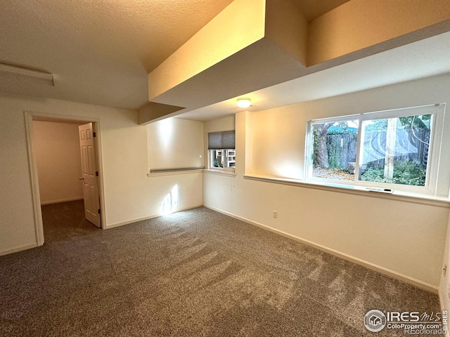 interior space with dark carpet and a textured ceiling