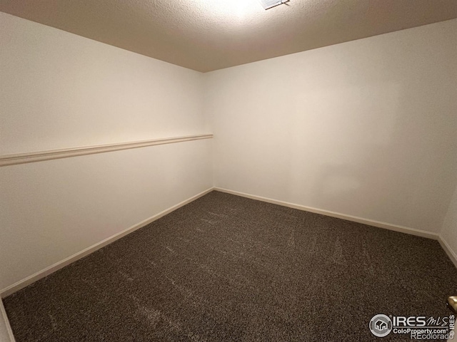 spare room featuring a textured ceiling and carpet