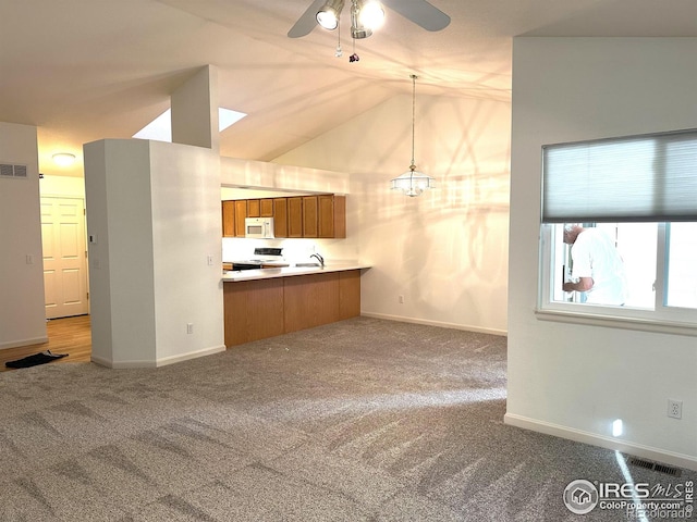 kitchen with electric stove, pendant lighting, ceiling fan with notable chandelier, and carpet