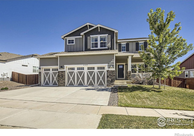 view of front of property with a front yard, a porch, and a garage