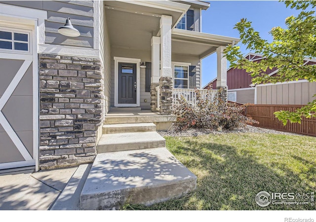 property entrance with covered porch and a yard