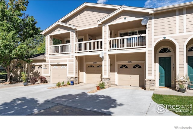 view of front of property featuring a balcony and a garage