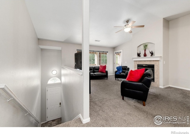 carpeted living room featuring ceiling fan and a tile fireplace