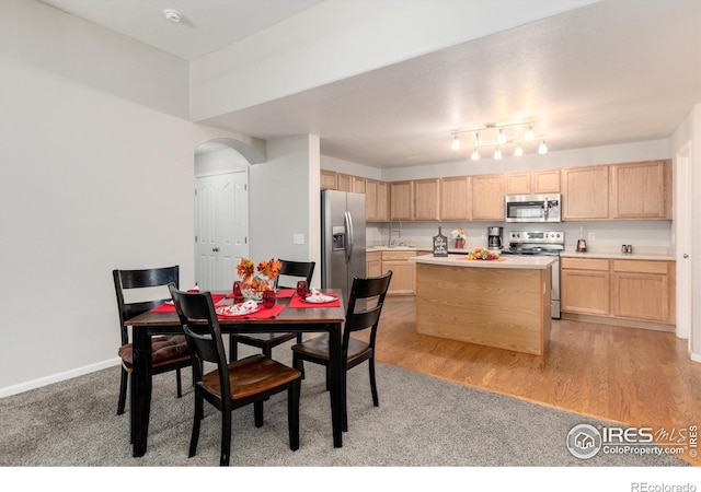 dining area with light hardwood / wood-style flooring and sink