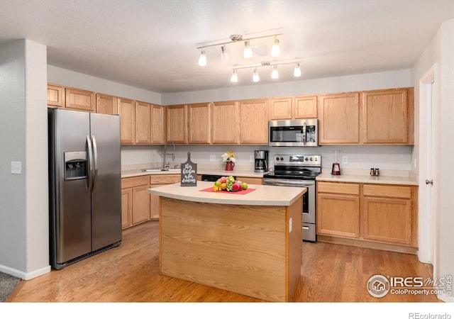 kitchen featuring light brown cabinetry, light wood-type flooring, appliances with stainless steel finishes, and sink