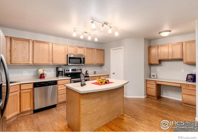 kitchen featuring light wood-type flooring, light brown cabinetry, a center island, and stainless steel appliances