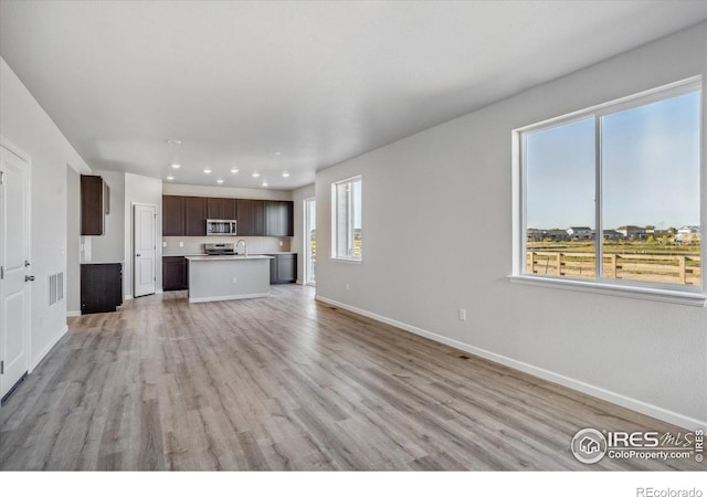 unfurnished living room with light hardwood / wood-style floors and a healthy amount of sunlight