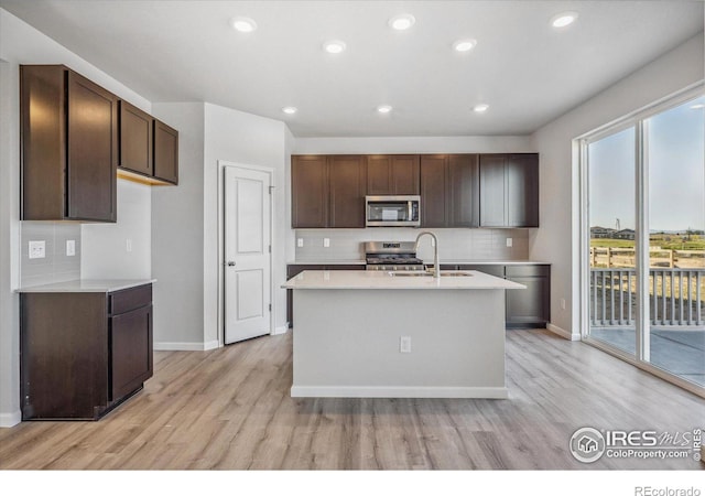 kitchen featuring light wood-type flooring, stainless steel appliances, plenty of natural light, and sink