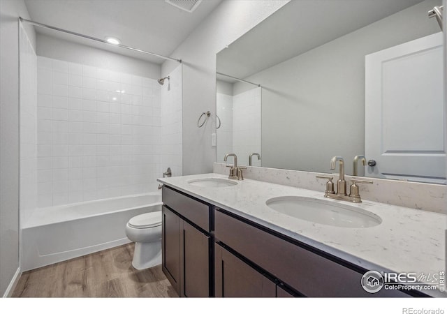 full bathroom with tiled shower / bath, vanity, toilet, and hardwood / wood-style flooring