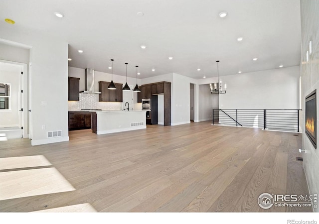 unfurnished living room with sink and light hardwood / wood-style flooring