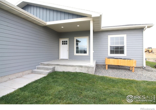 doorway to property featuring a lawn