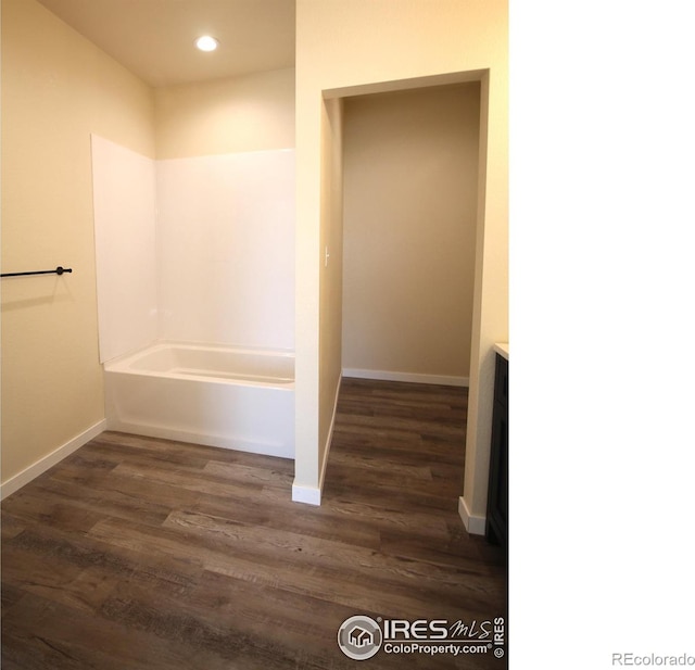 bathroom with hardwood / wood-style flooring and a bathtub