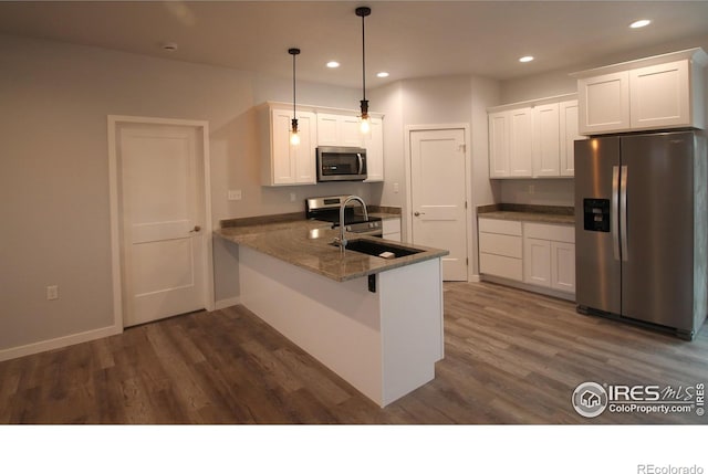 kitchen with stainless steel appliances, white cabinetry, and dark wood-type flooring