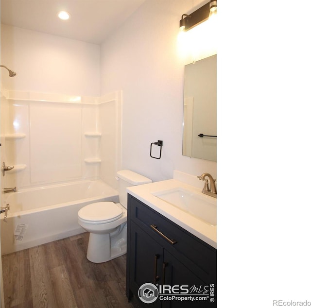 full bathroom with toilet, vanity, hardwood / wood-style flooring, and bathing tub / shower combination