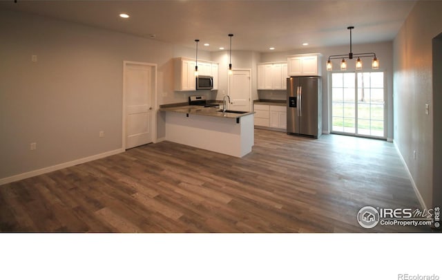 kitchen with white cabinets, hanging light fixtures, and appliances with stainless steel finishes