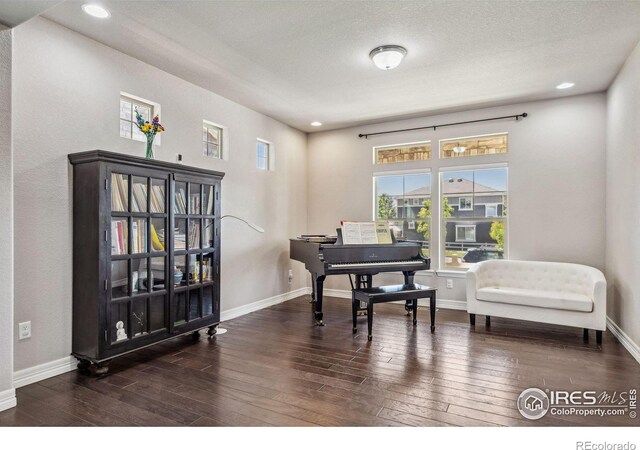 sitting room with a textured ceiling, recessed lighting, wood-type flooring, and baseboards