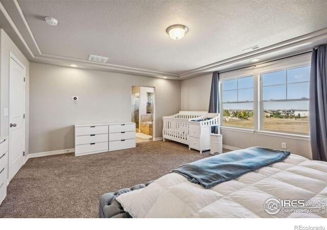 carpeted bedroom with baseboards, connected bathroom, visible vents, and a textured ceiling