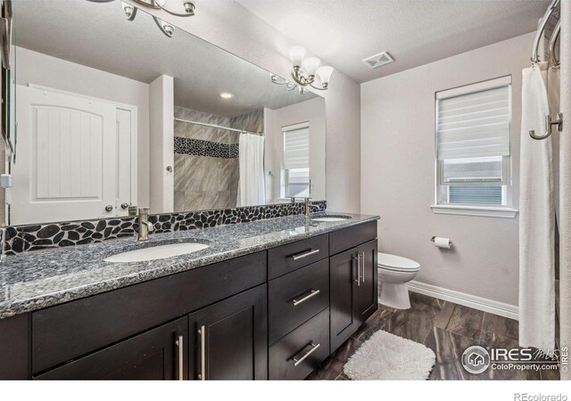 bathroom featuring toilet, baseboards, visible vents, and a sink