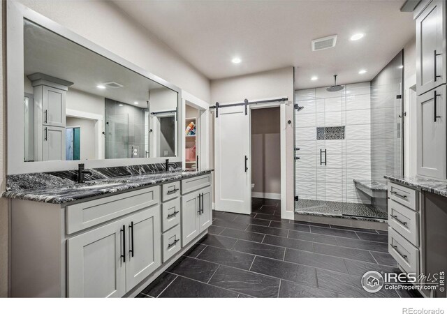 bathroom featuring double vanity, a shower stall, visible vents, and recessed lighting