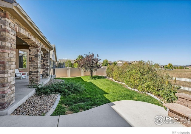 view of yard featuring a patio and fence