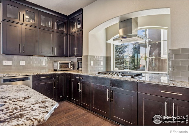 kitchen with a toaster, stainless steel appliances, dark wood-type flooring, island range hood, and light stone countertops