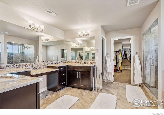 full bath with a spacious closet, a shower stall, visible vents, and an inviting chandelier