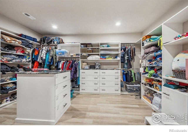 spacious closet featuring light wood-type flooring and visible vents